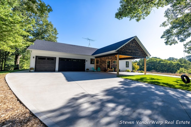 12640 Bucs Dr, Grand Haven, MI 49417 - view of front of home with a garage, driveway, a porch, and a front yard