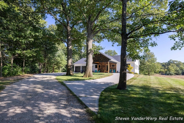 12640 Bucs Dr, Grand Haven, MI 49417 - view of front facade featuring gravel driveway, a front lawn, and stone siding