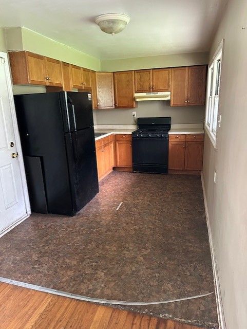 21383 Mada Ave, Southfield, MI 48075 - kitchen featuring black appliances, under cabinet range hood, light countertops, and brown cabinetry