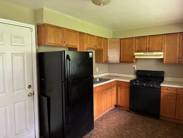 21383 Mada Ave, Southfield, MI 48075 - kitchen featuring black appliances, brown cabinetry, under cabinet range hood, and light countertops