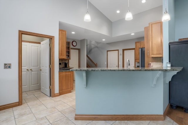 1355 W Buell Rd, Oakland, MI 48363 - kitchen with a breakfast bar, a peninsula, stone countertops, baseboards, and recessed lighting