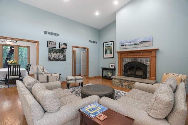 1355 W Buell Rd, Oakland, MI 48363 - living room with high vaulted ceiling, light wood-style flooring, a tiled fireplace, recessed lighting, and baseboards