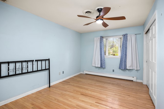 14240 Rosemont Ave, Detroit, MI 48223 - unfurnished bedroom featuring a baseboard radiator, a closet, wood finished floors, and baseboards