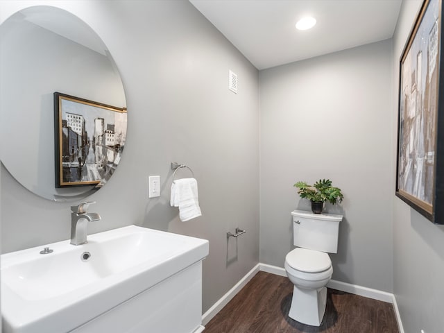 576 E Flint St, Lake Orion, MI 48362 - bathroom with a sink, wood finished floors, toilet, baseboards, and recessed lighting