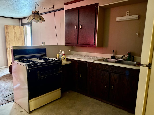 kitchen with range with gas cooktop, a sink, light countertops, light colored carpet, and freestanding refrigerator