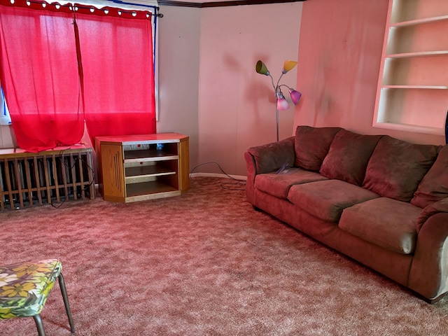 carpeted living room featuring radiator heating unit and baseboards