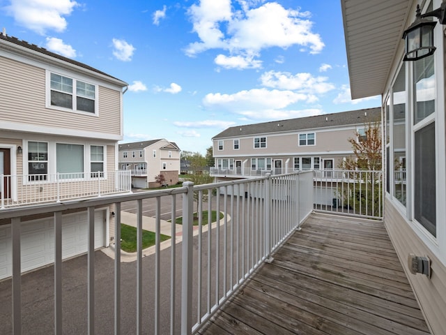 wooden terrace with a residential view, a garage, and driveway