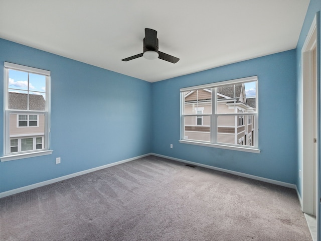 carpeted empty room with baseboards and ceiling fan