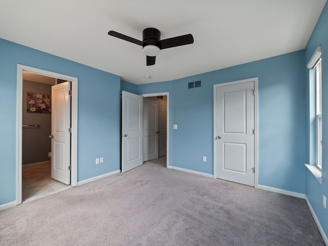 unfurnished bedroom featuring carpet flooring, baseboards, a ceiling fan, and ensuite bathroom