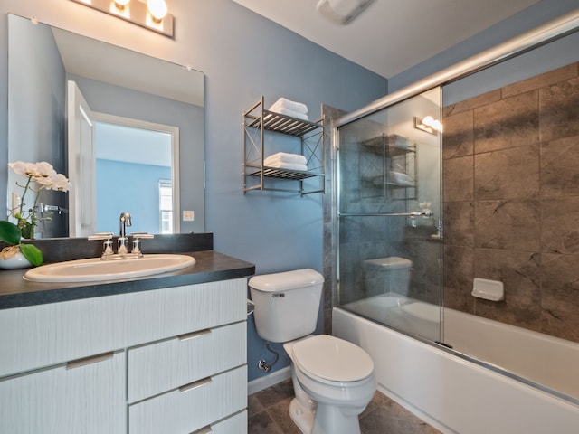 bathroom featuring toilet, vanity, and shower / bath combination with glass door