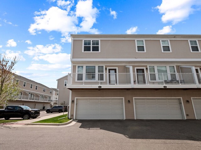 townhome / multi-family property featuring a garage and asphalt driveway