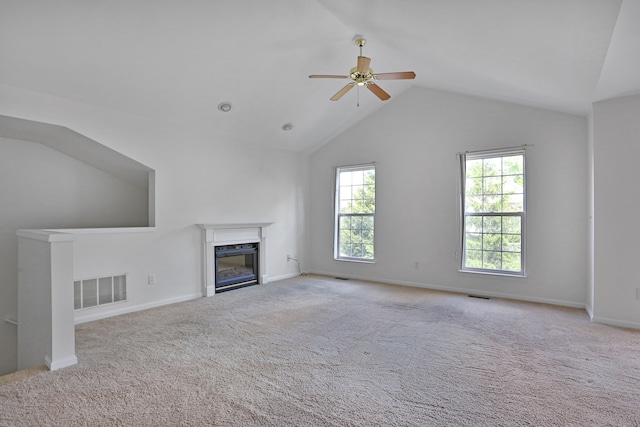 unfurnished living room featuring a ceiling fan, a glass covered fireplace, lofted ceiling, carpet flooring, and baseboards