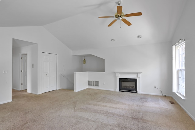 unfurnished living room with lofted ceiling, carpet, ceiling fan, a glass covered fireplace, and baseboards