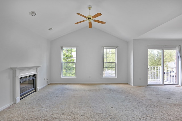 unfurnished living room with a glass covered fireplace, carpet flooring, ceiling fan, lofted ceiling, and baseboards