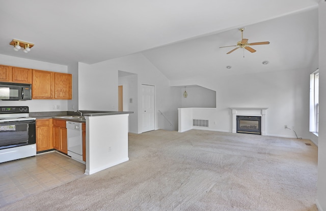 kitchen featuring white appliances, vaulted ceiling, a sink, a ceiling fan, and open floor plan