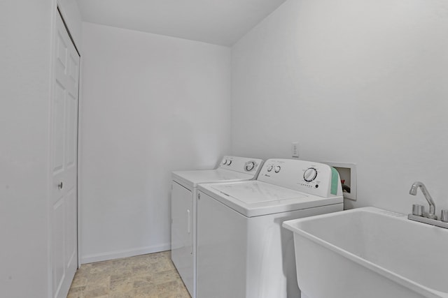 clothes washing area with independent washer and dryer and baseboards