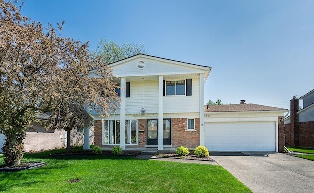 view of front of property with brick siding, concrete driveway, a front lawn, and a garage