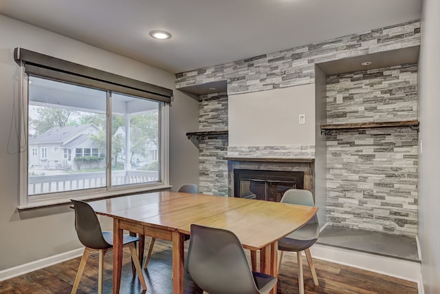 dining area with a fireplace, wood finished floors, and baseboards