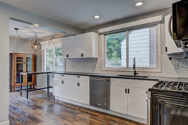 kitchen with a sink, stainless steel appliances, dark countertops, white cabinets, and healthy amount of natural light