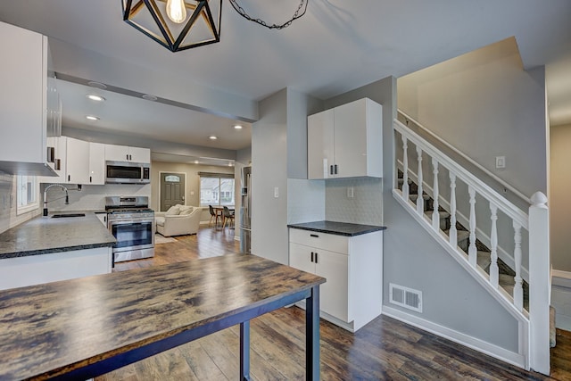 kitchen featuring stainless steel appliances, dark wood-style floors, dark countertops, tasteful backsplash, and recessed lighting