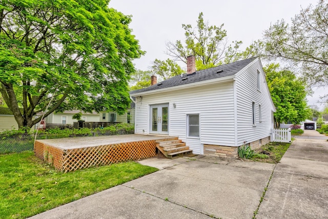 back of house with french doors, a chimney, and a wooden deck