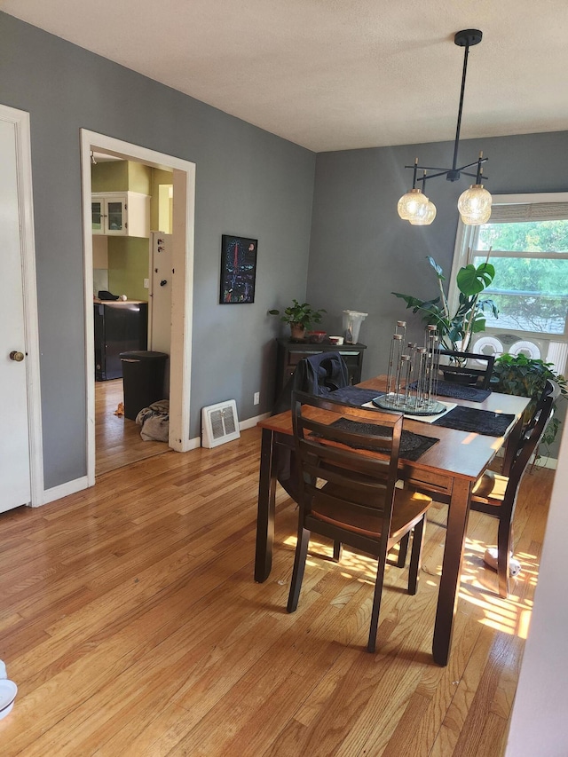 dining area featuring light wood-style floors and baseboards