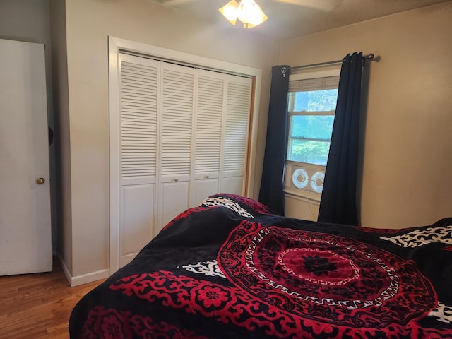 bedroom with light wood-style floors, a closet, and baseboards
