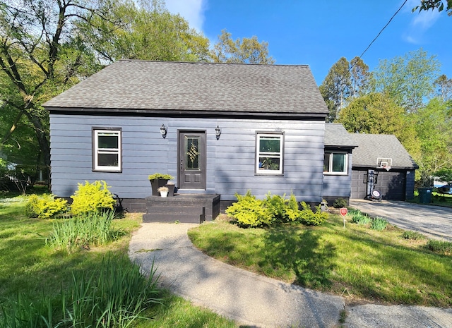 view of front of property with a shingled roof and a front yard