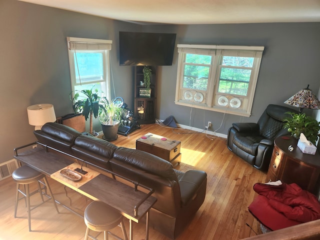 living room with plenty of natural light, wood finished floors, and baseboards