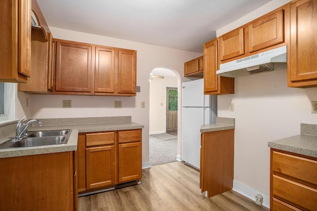 8 Vernon Ave, Battle Creek, MI 49014 - kitchen featuring freestanding refrigerator, under cabinet range hood, arched walkways, a sink, and light wood-style flooring