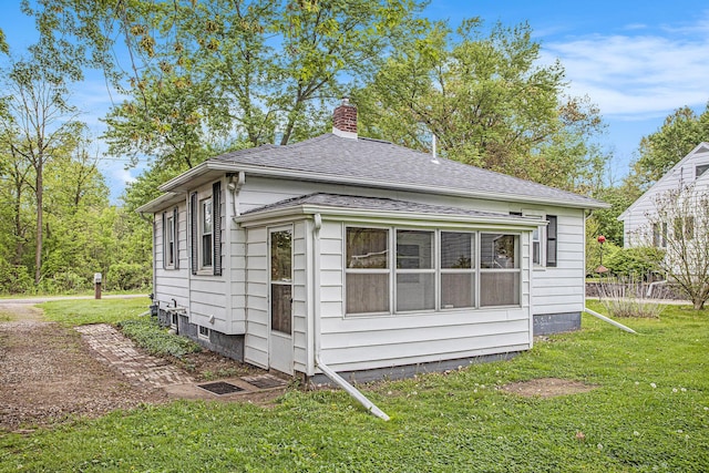 8 Vernon Ave, Battle Creek, MI 49014 - view of side of property featuring a chimney, a yard, and a shingled roof