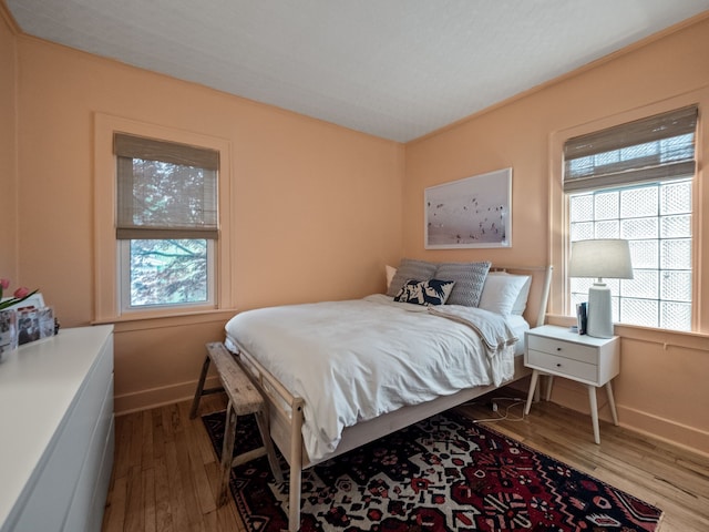bedroom with wood finished floors and baseboards