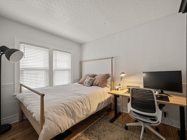 bedroom with wood finished floors and a textured ceiling