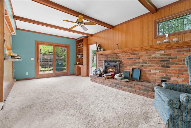 2020 NW Ave, Lansing, MI 48906 - living room featuring beamed ceiling, carpet floors, ceiling fan, wood walls, and a brick fireplace