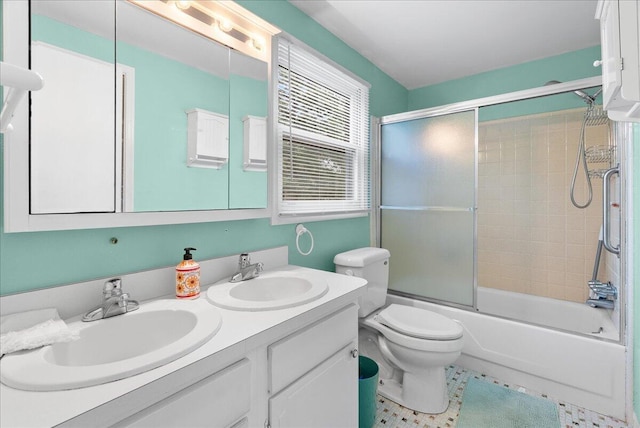 2020 NW Ave, Lansing, MI 48906 - full bathroom featuring double vanity, toilet, bath / shower combo with glass door, and tile patterned flooring