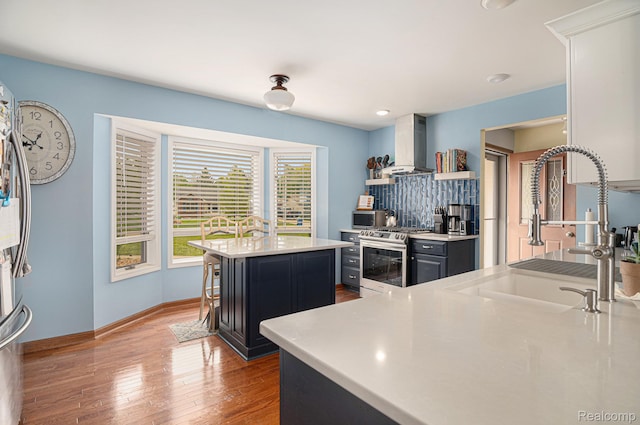 5361 Lin Hill Dr, Swartz Creek, MI 48473 - kitchen featuring appliances with stainless steel finishes, island exhaust hood, a center island, wood finished floors, and a sink