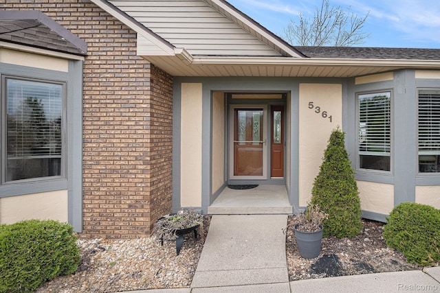 5361 Lin Hill Dr, Swartz Creek, MI 48473 - doorway to property featuring brick siding, stucco siding, and roof with shingles
