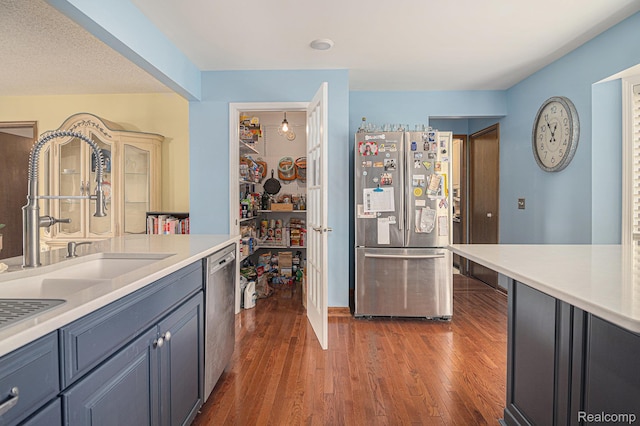 5361 Lin Hill Dr, Swartz Creek, MI 48473 - kitchen with stainless steel appliances, a sink, light countertops, and dark wood finished floors