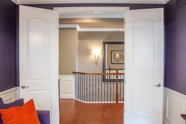 5514 Woodfall Rd, Clarkston, MI 48348 - hall featuring a wainscoted wall, a decorative wall, wood finished floors, an upstairs landing, and ornamental molding