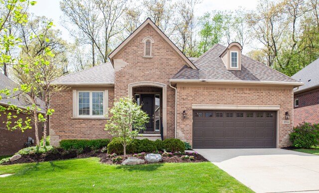 5514 Woodfall Rd, Clarkston, MI 48348 - view of front facade featuring a shingled roof, brick siding, a garage, a front yard, and driveway