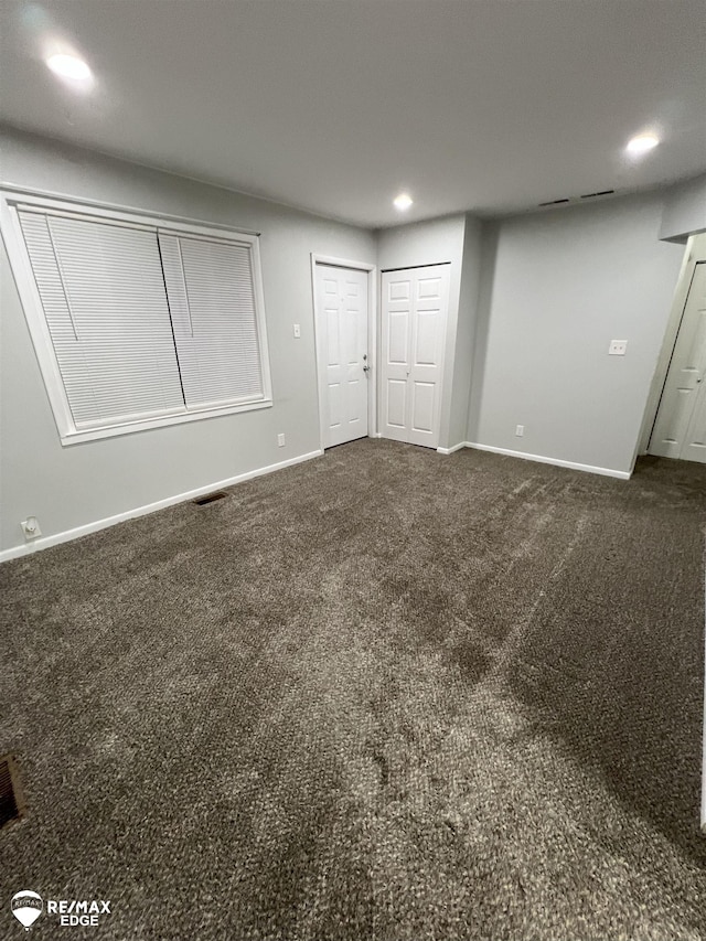 1132 Wisner St, Mount Morris, MI 48458 - unfurnished bedroom featuring two closets, dark colored carpet, and recessed lighting