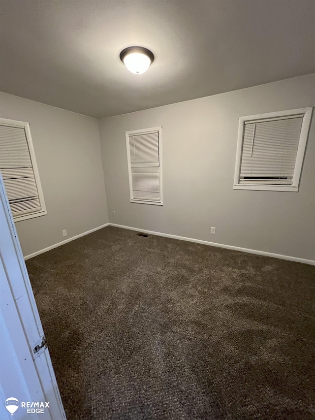 1132 Wisner St, Mount Morris, MI 48458 - empty room with dark carpet and baseboards