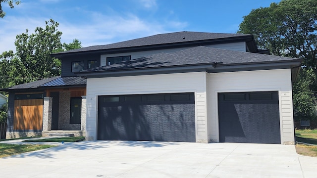 view of front facade featuring concrete driveway, an attached garage, and a shingled roof