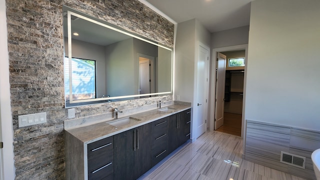 bathroom featuring double vanity and a spacious closet