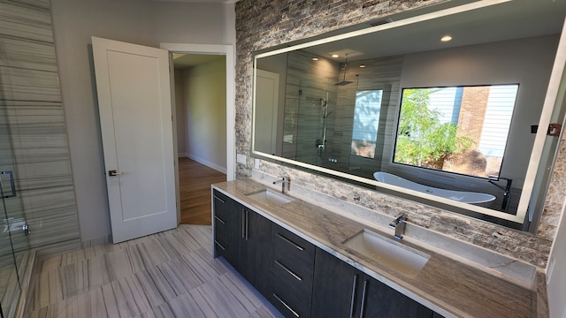 full bathroom featuring a shower stall, double vanity, and a tub to relax in