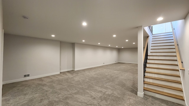 finished below grade area featuring carpet floors, stairs, baseboards, and recessed lighting