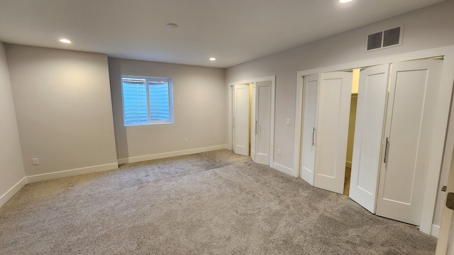 unfurnished bedroom featuring multiple closets, carpet flooring, recessed lighting, and baseboards