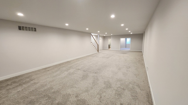 basement featuring recessed lighting, stairway, light carpet, and baseboards