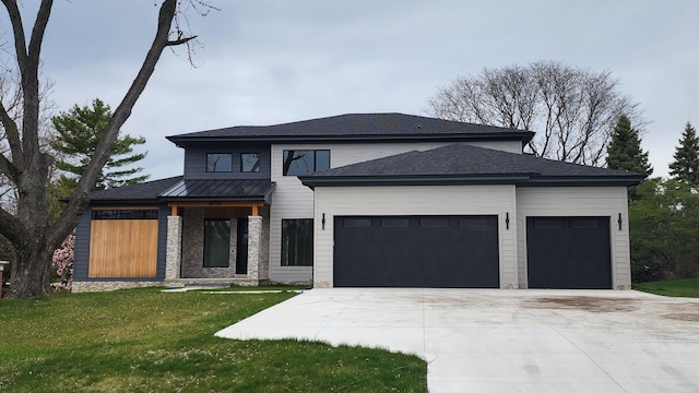 view of front of home featuring a garage, concrete driveway, and a front yard