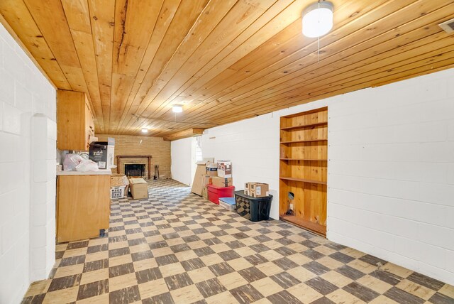 below grade area with tile patterned floors, wooden ceiling, and a fireplace